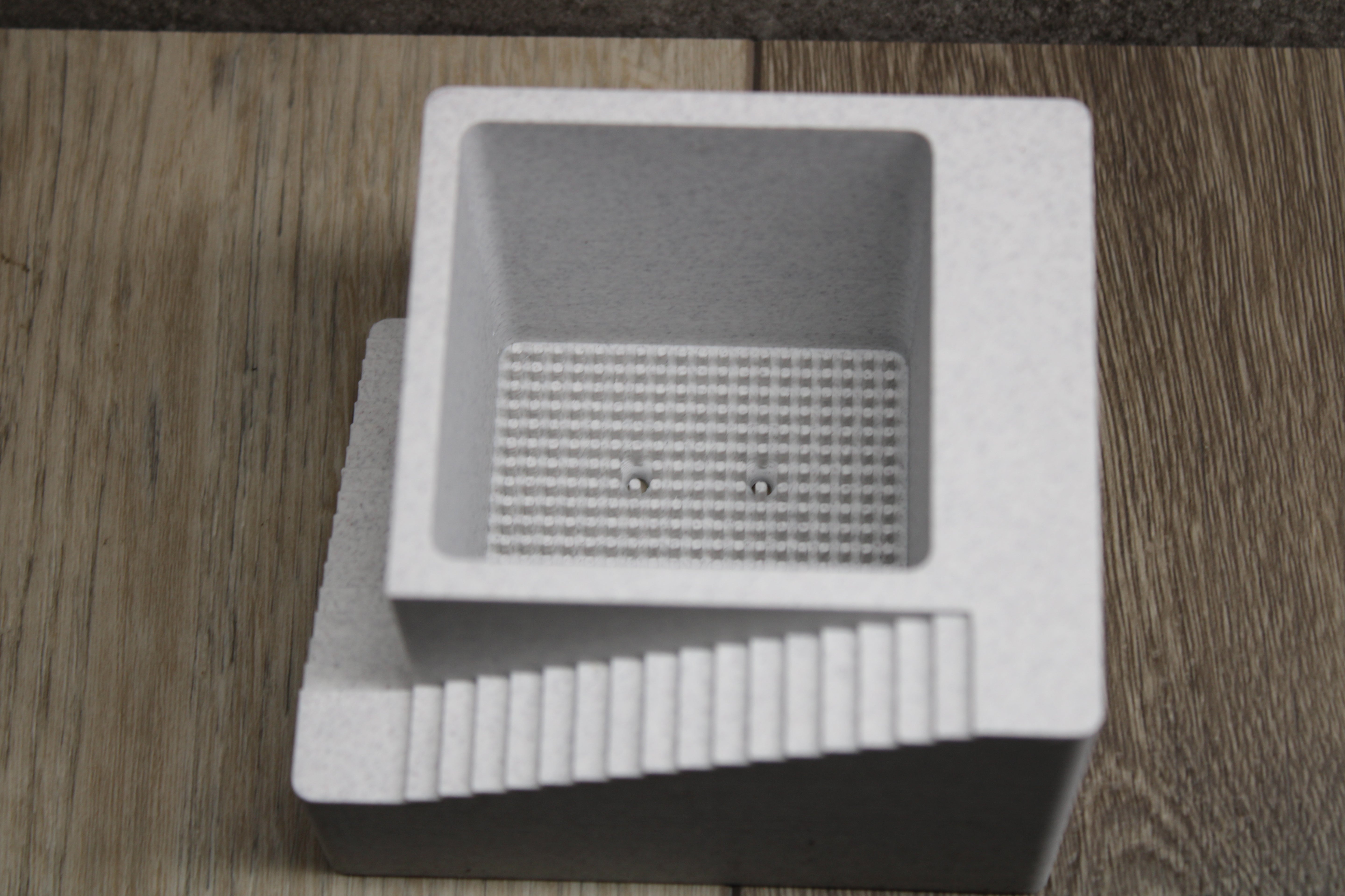Small indoor planter with drainage holes and architectural style